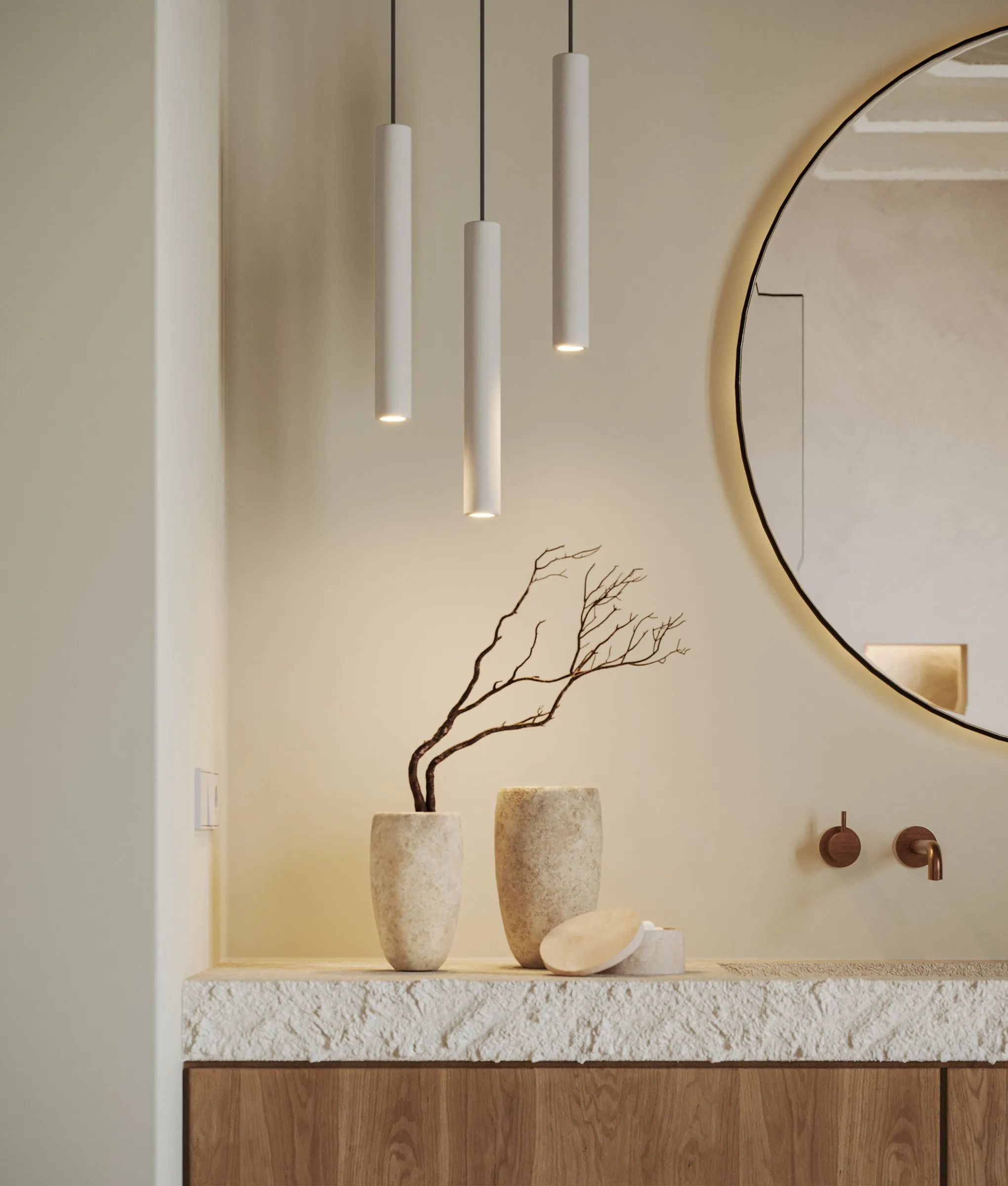 Baño con lavabo de piedra y espejo redondo en la vivienda Asprer