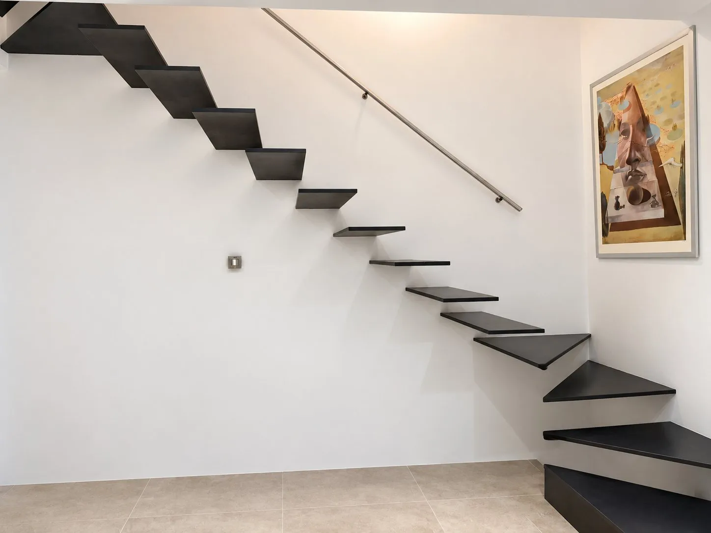 Escalera de chapa de acero negra volada sobre el muro blanco de la Casa Aina en Pollença