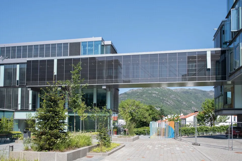 Pasarela acristalada que une dos edificios de Glassblokkene, con las montañas de Bergen detrás