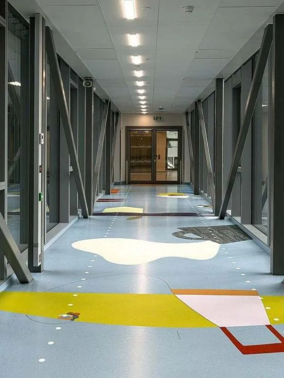 Pasillo interior de Glassblokkene con suelo de colores y estructura vista
