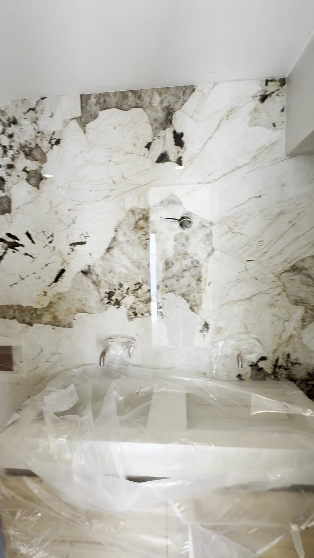 Baño del apartamento Salzes revestido de piedra veteada