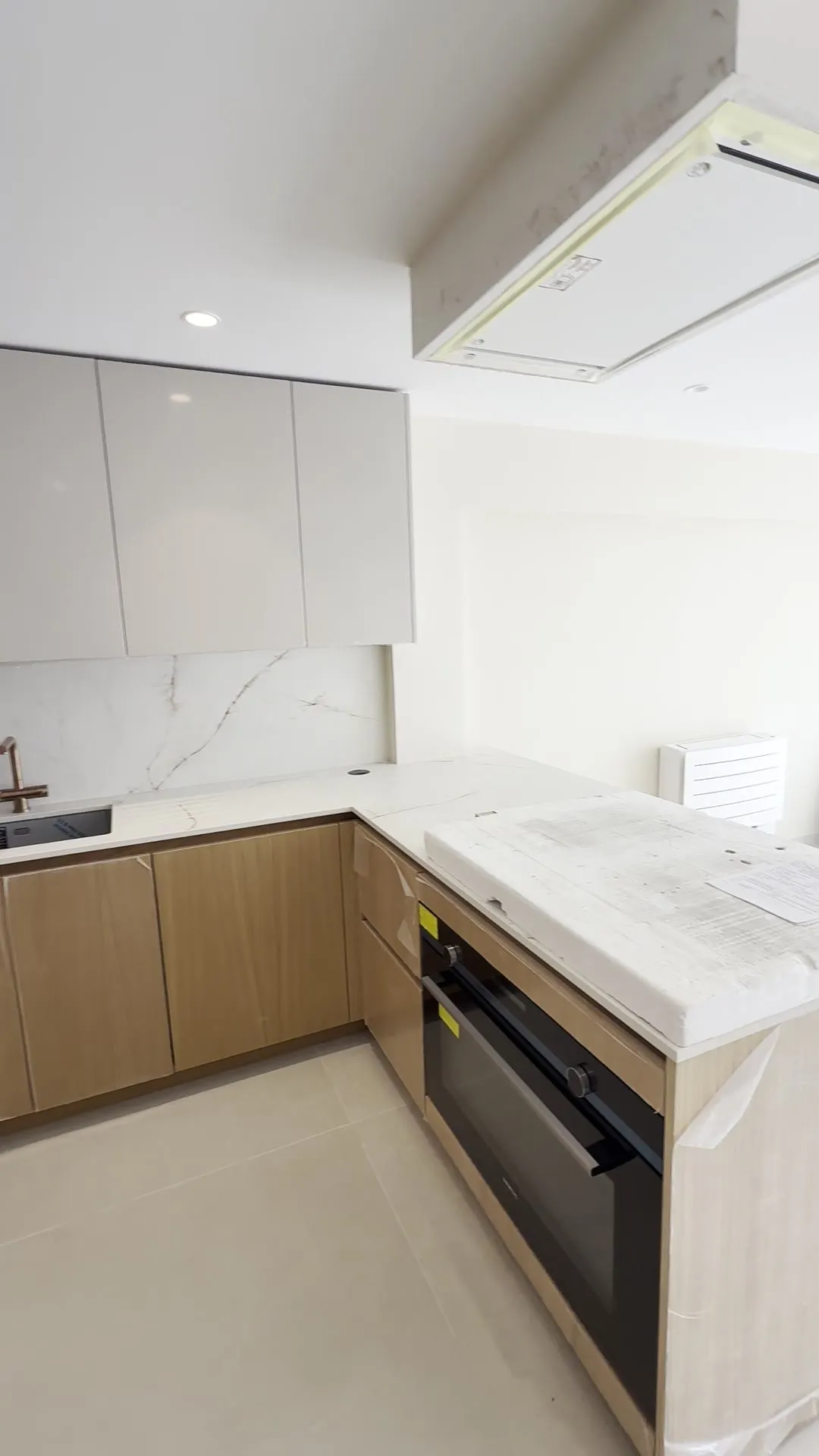 Cocina nueva del apartamento Salzes con frentes claros y encimera de piedra