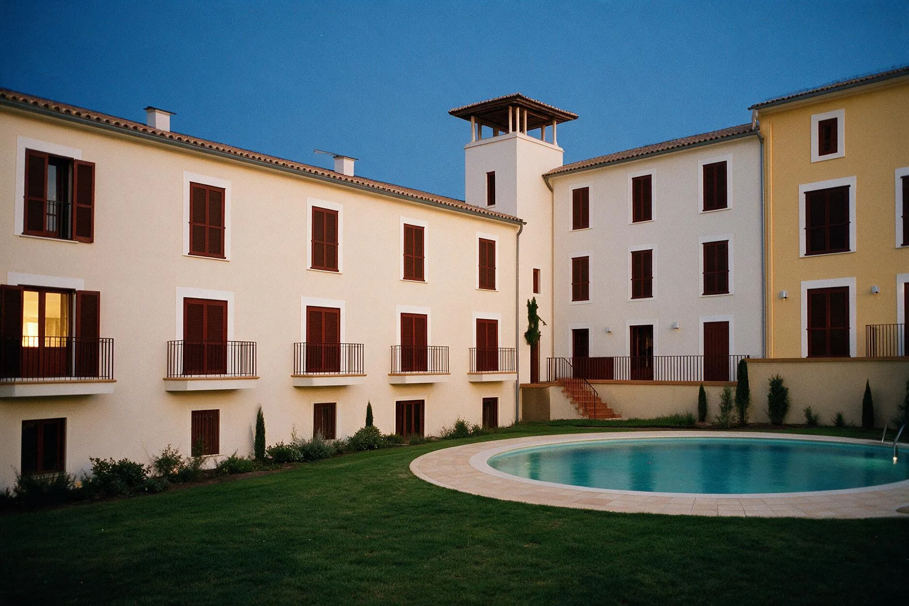 El patio de Son Pastor al anochecer, con las primeras ventanas encendidas